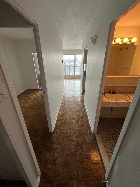 a view of a hallway with a bathroom and a sink