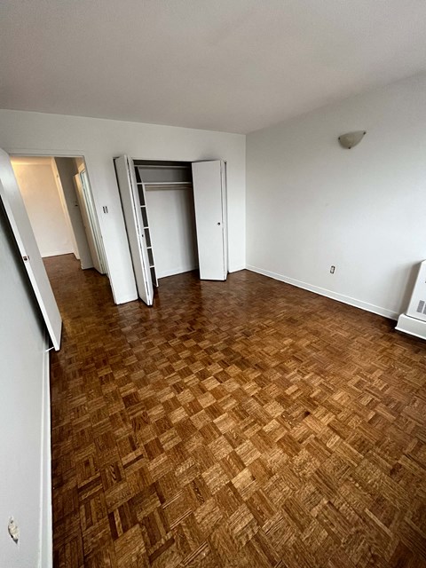 an empty living room with wood flooring and white walls