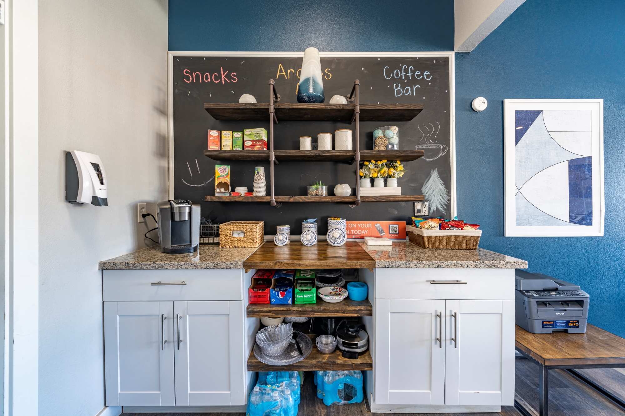 a kitchen with a counter and a chalkboard wall with a coffee bar