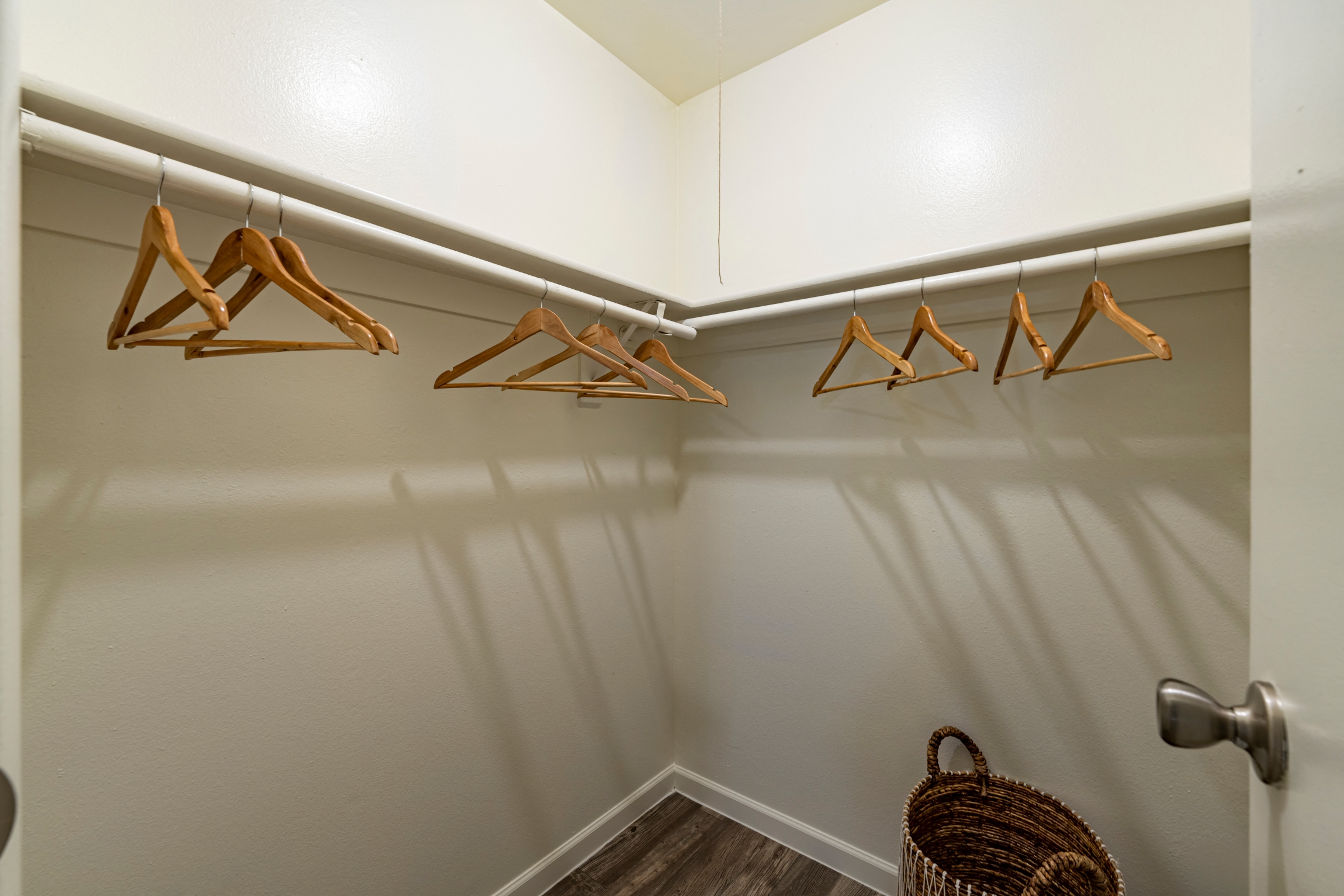 a walk in closet with clothes hangers and a door