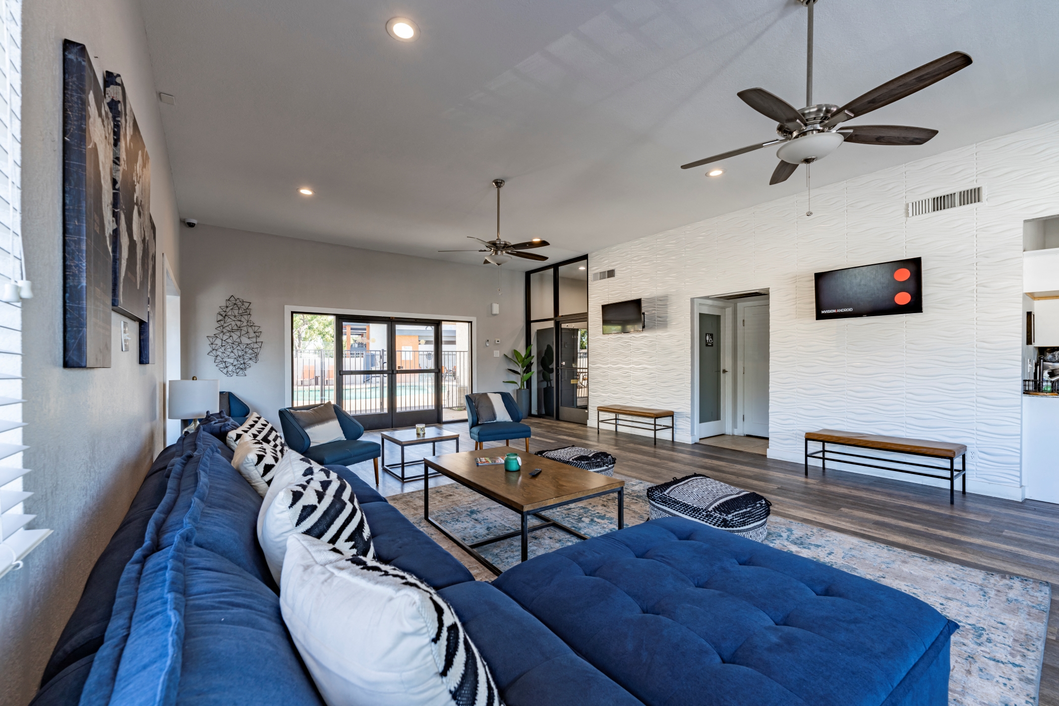 a living room with a blue couch and a ceiling fan