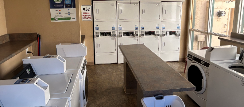 a laundry room with a washer and dryer and a counter with a sink