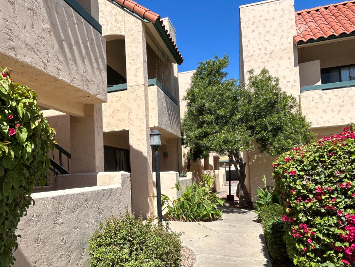 a sidewalk between two buildings in a courtyard