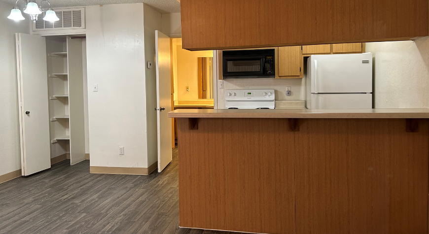 a kitchen with a stove and a refrigerator in a room