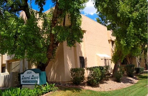 a building with a sign in front of it and some trees
