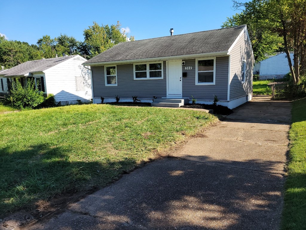 A small house with a white door and a grey roof.