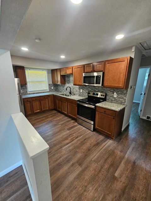 A kitchen with wooden cabinets and a stove top oven.