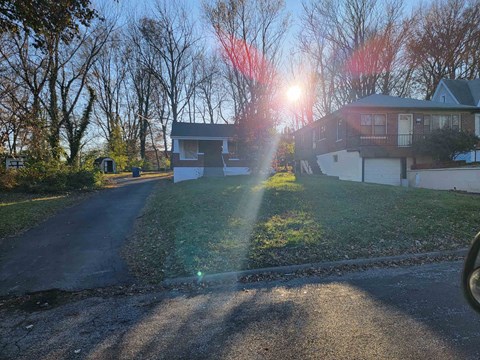 A house with a driveway and trees in the background.