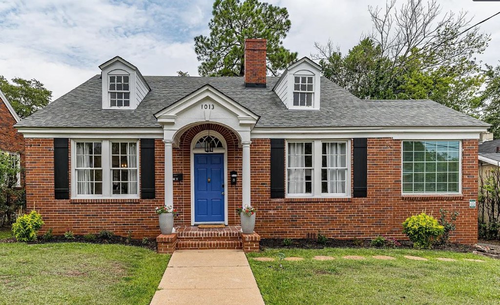 the front of a brick house with a blue door