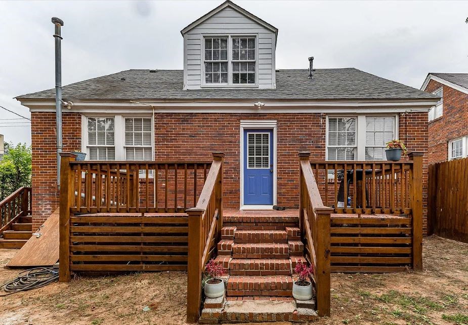 a house with a wooden deck and a blue door
