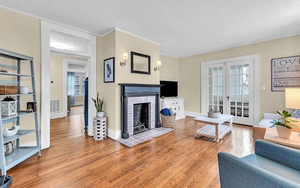 a living room with a fireplace and a door to a balcony