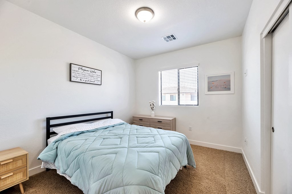 a bedroom with a bed and a dresser and a window