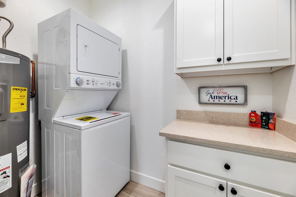 a laundry room with a washer and dryer and a counter with a refrigerator