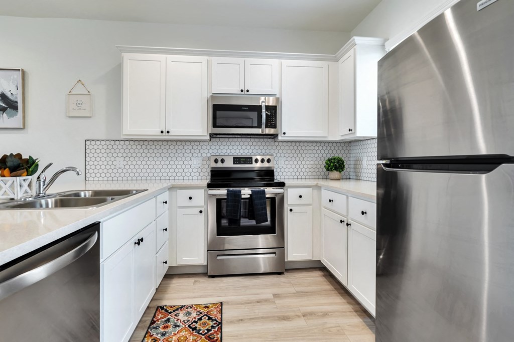 a kitchen with stainless steel appliances and white cabinets