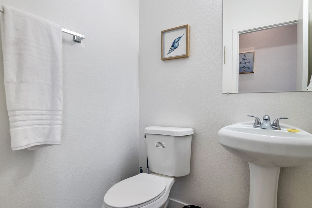 a bathroom with a toilet sink and a mirror