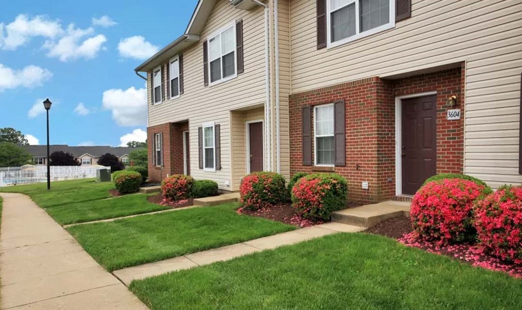 the front of a house with a sidewalk and landscaping