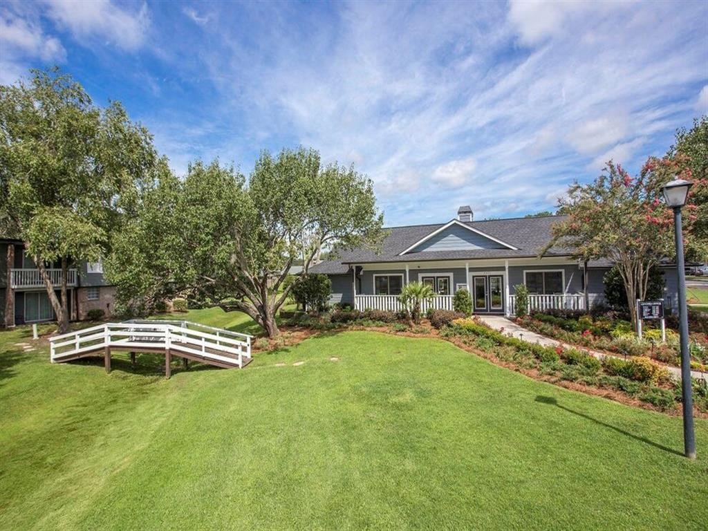 a large yard with a white fence in front of a house