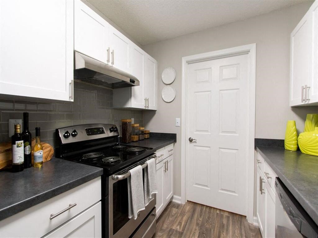 a white kitchen with a stove and a door