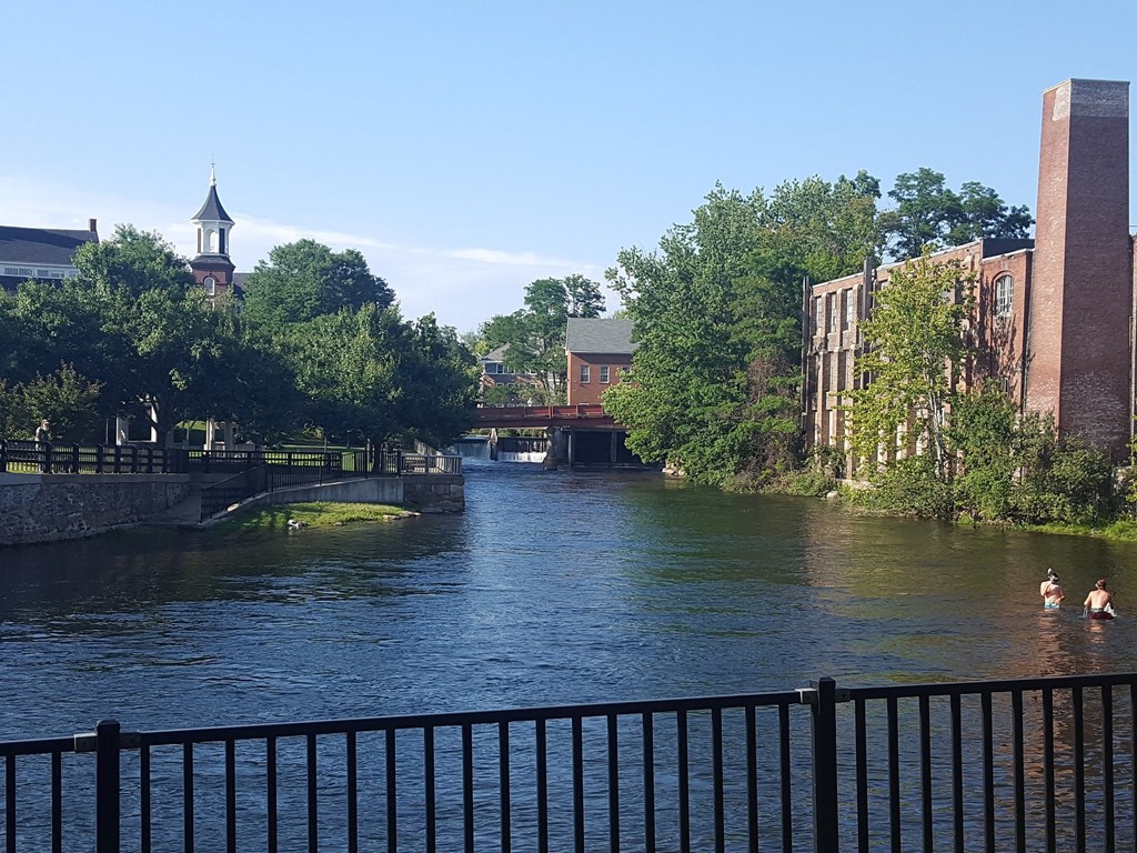 a river flowing through a city with buildings and a bridge