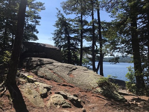 a large rock sitting next to a body of water