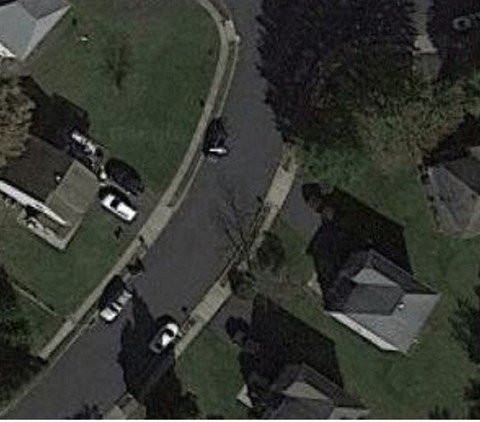 A residential area with houses and cars.