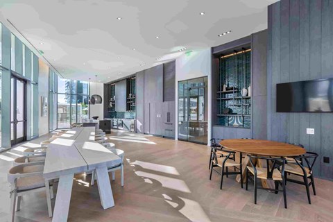 A modern dining room with a long table and chairs.