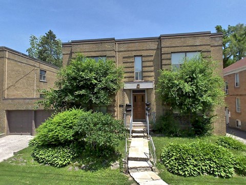 A house with a brown brick exterior and a wooden front door.