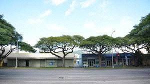 an empty parking lot with trees in front of a building