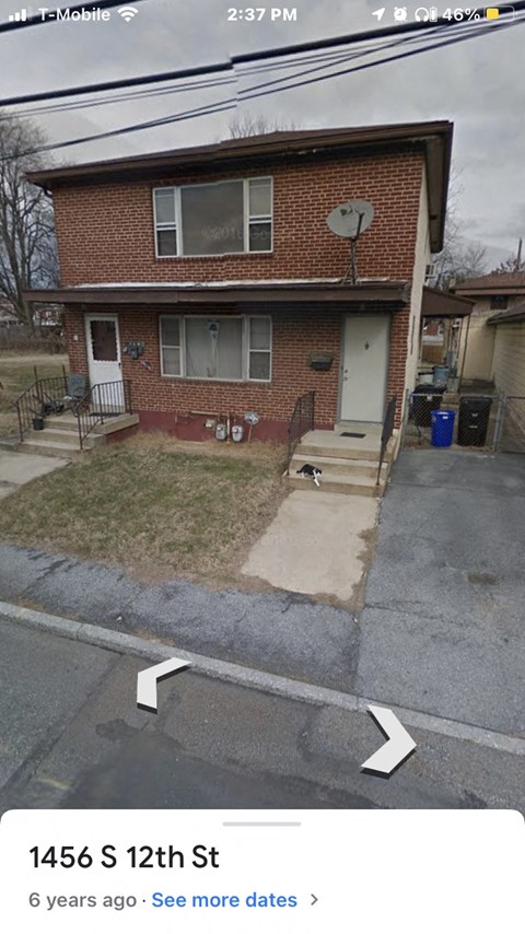 the front of a brick house with a satellite dish on the roof