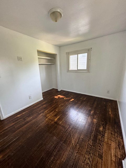 a living room with a hard wood floor and a window