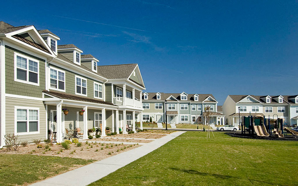 a row of houses on the side of a sidewalk