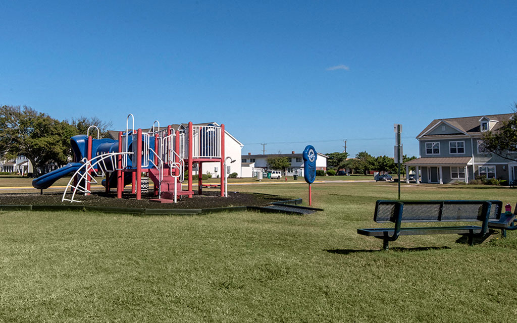 a playground with a slide and a bench in a park