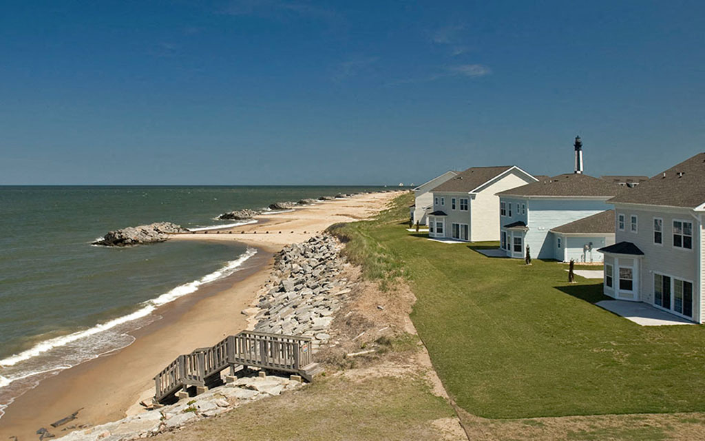 a row of houses on the beach next to the ocean