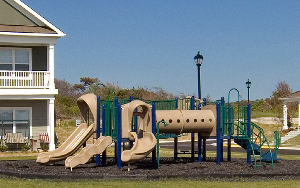 a playground with slides and other toys in front of a house