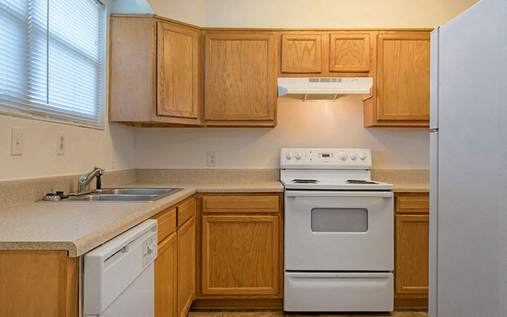 a kitchen with white appliances and wooden cabinets