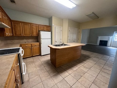 a large kitchen with a sink and a refrigerator