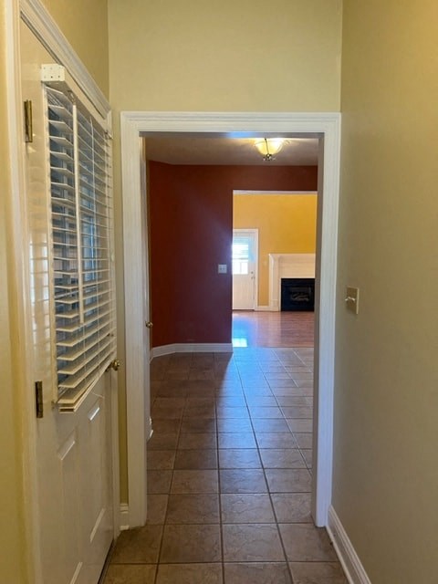 a hallway with an open door and a tiled floor