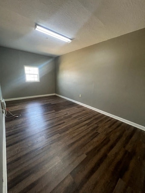 an empty room with wooden floors and a window