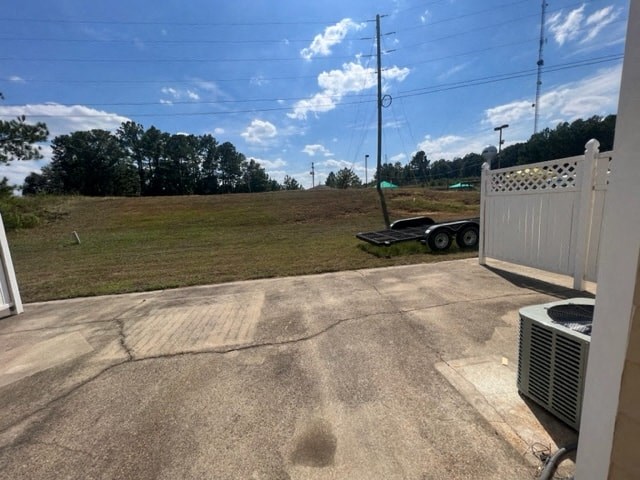a view of the driveway of a house with a field in the background