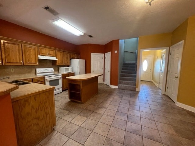 a kitchen with a stove a refrigerator and a sink