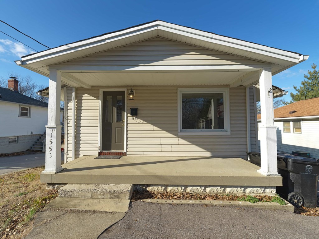 A small house with a porch and a mailbox on the front.