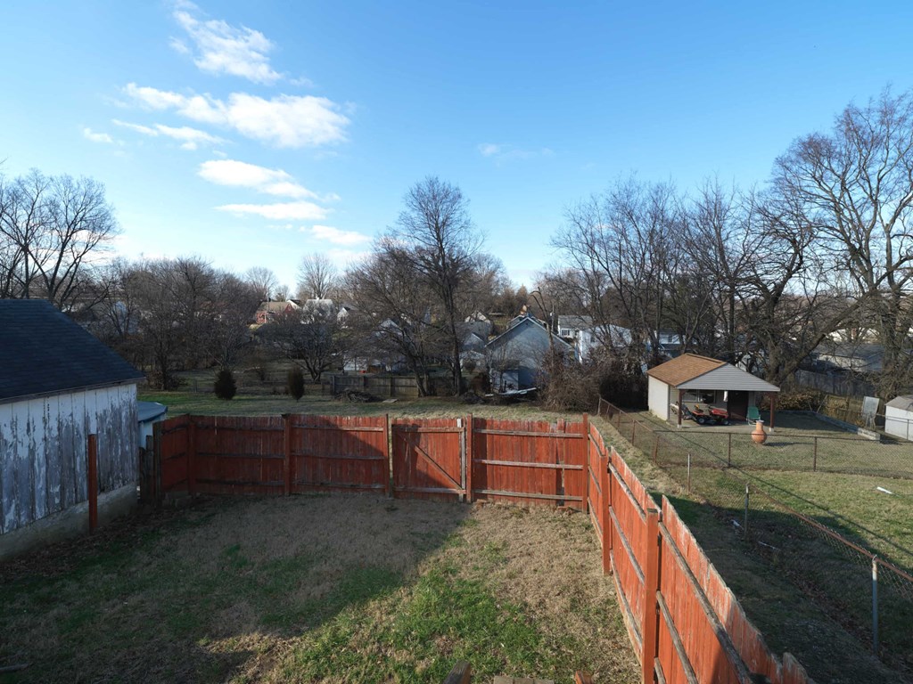 A backyard with a fence and a shed.