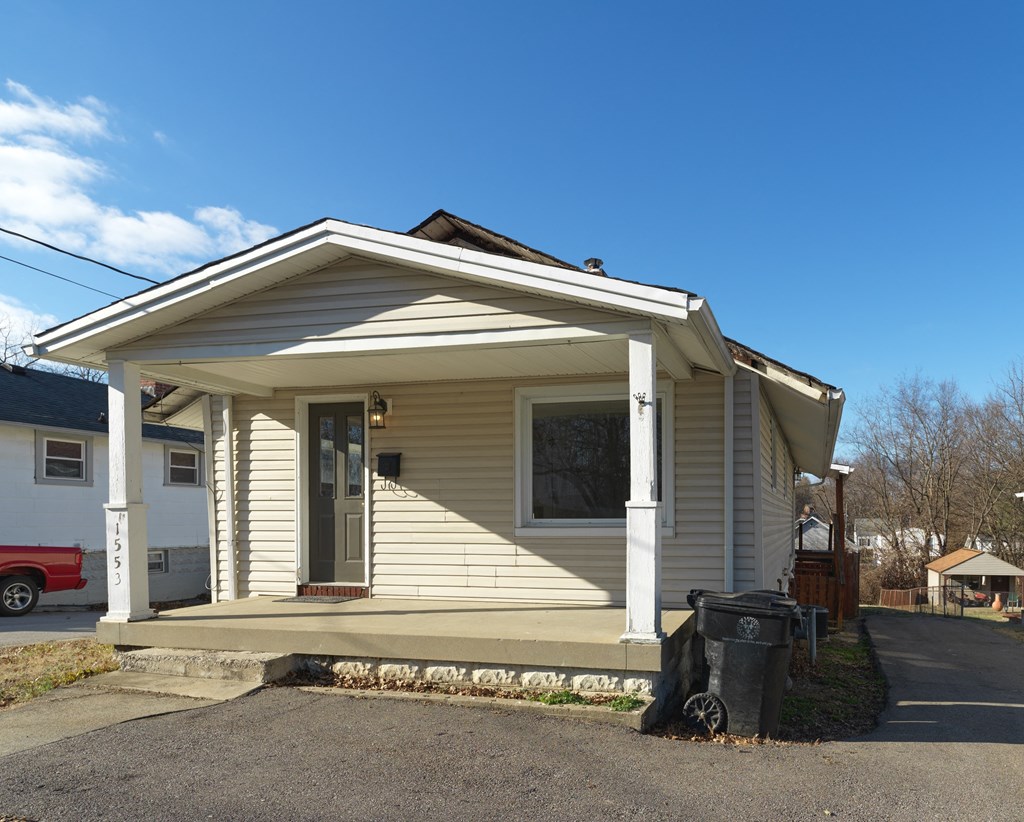 A small house with a red truck parked in front.