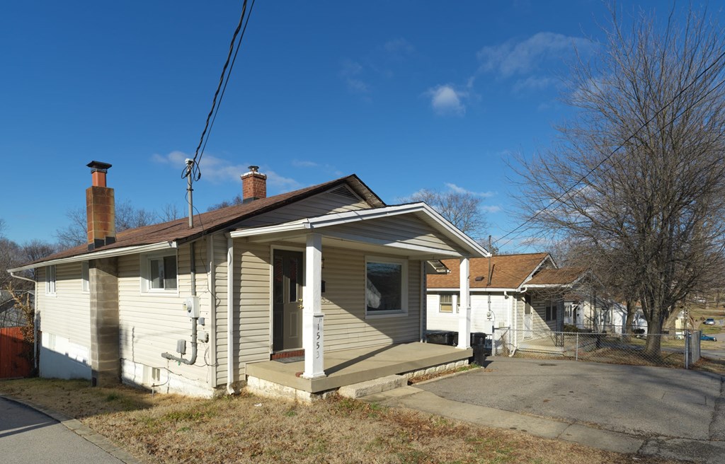 A house with a grey siding and a brown roof is shown.