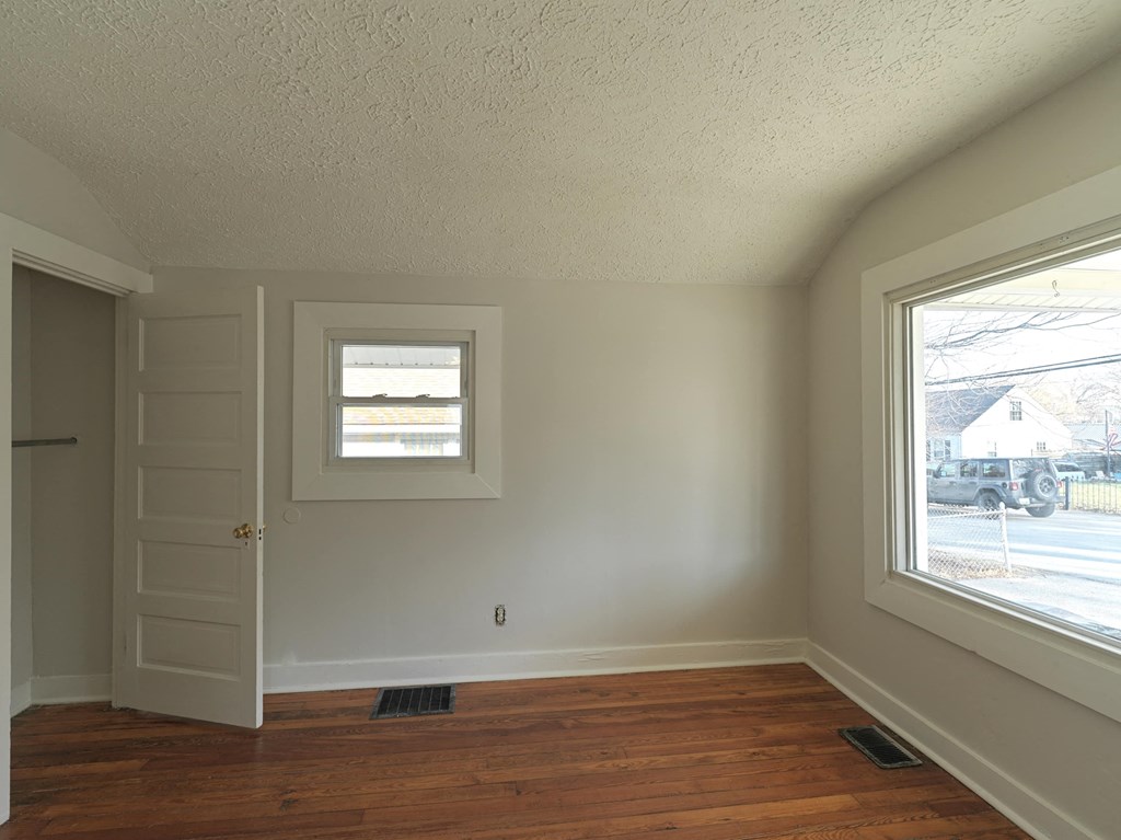 A room with a wooden floor and a window.