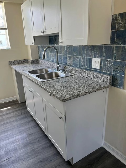 A kitchen with a granite countertop and a sink.