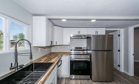 A modern kitchen with stainless steel appliances and wooden countertops.