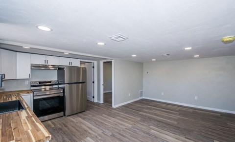 A kitchen with a wooden counter top and stainless steel appliances.