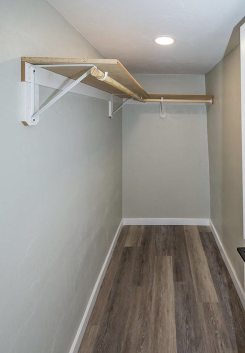 A white wall with a wooden shelf above it.