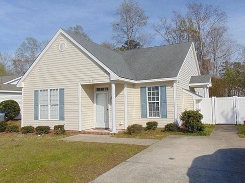 A house with a white picket fence in front.